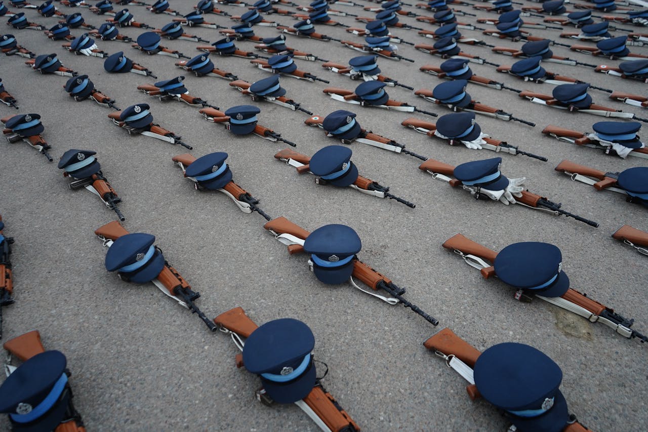 A neat pattern of military hats with rifles symbolizing order and discipline on parade ground.
